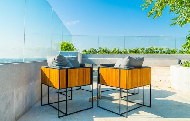 Petite terrasse aménagée avec une table, des chaises et un coin détente séparé
