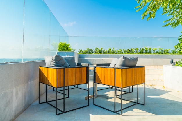 Petite terrasse aménagée avec une table, des chaises et un coin détente séparé